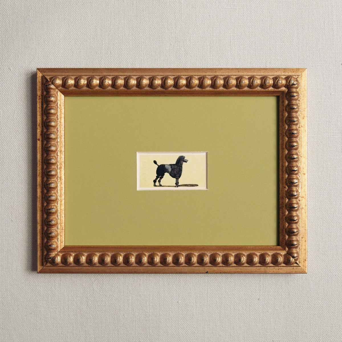 Handmade bobbin frame in antique style gold with green mount, framing a mid century lithograph of a poodle. Only available at Giddy Prints. 