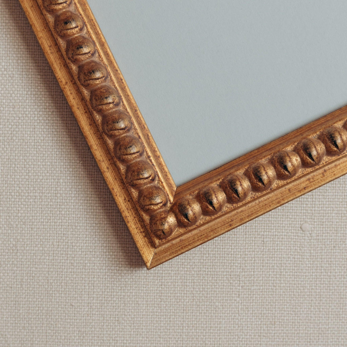 Detailed corner shot of handmade bobbin frame in antique style gold with blue mount. Available only at Giddy Prints.